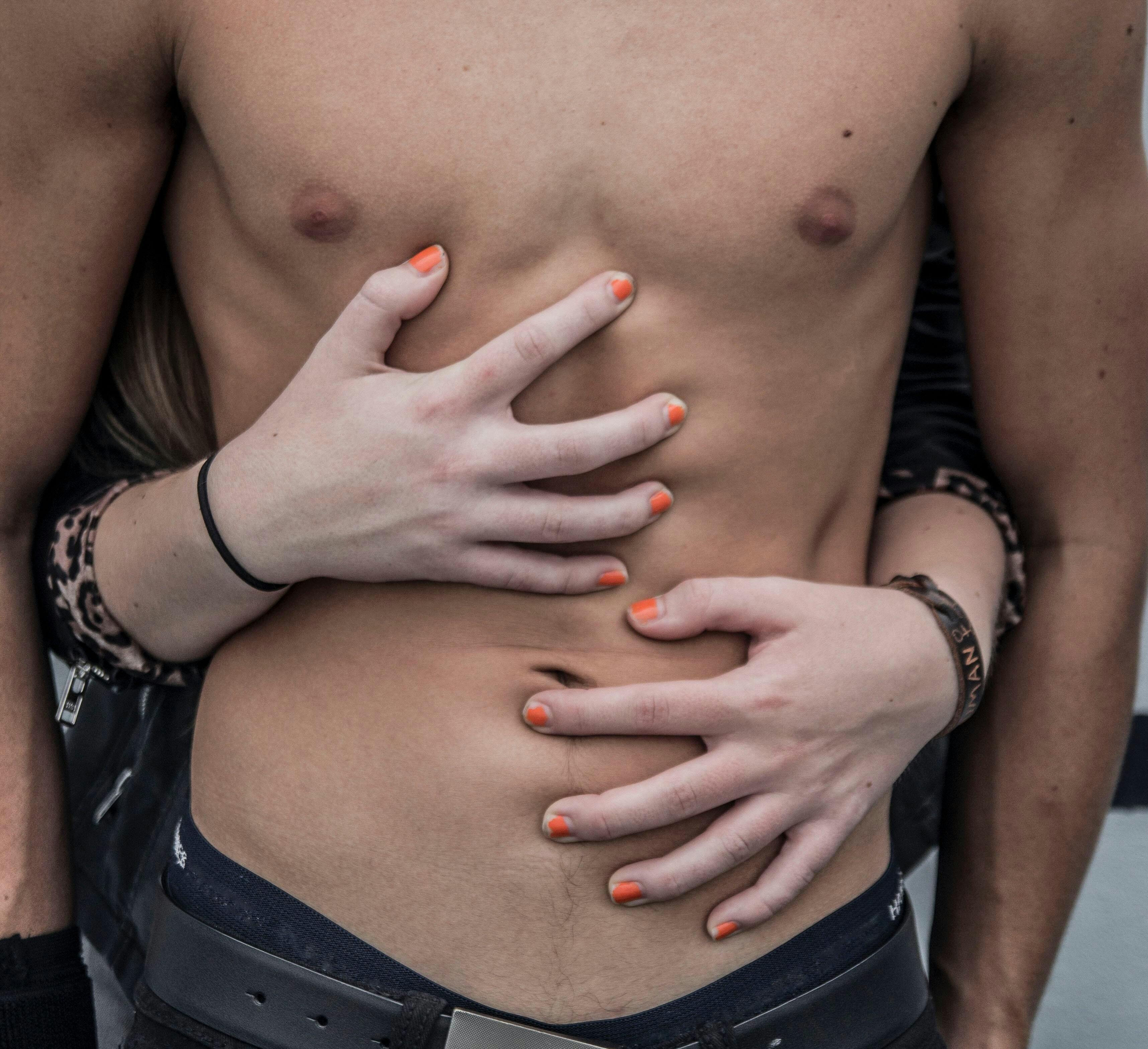 Woman's hands on a man's abdomen for Good Vibes